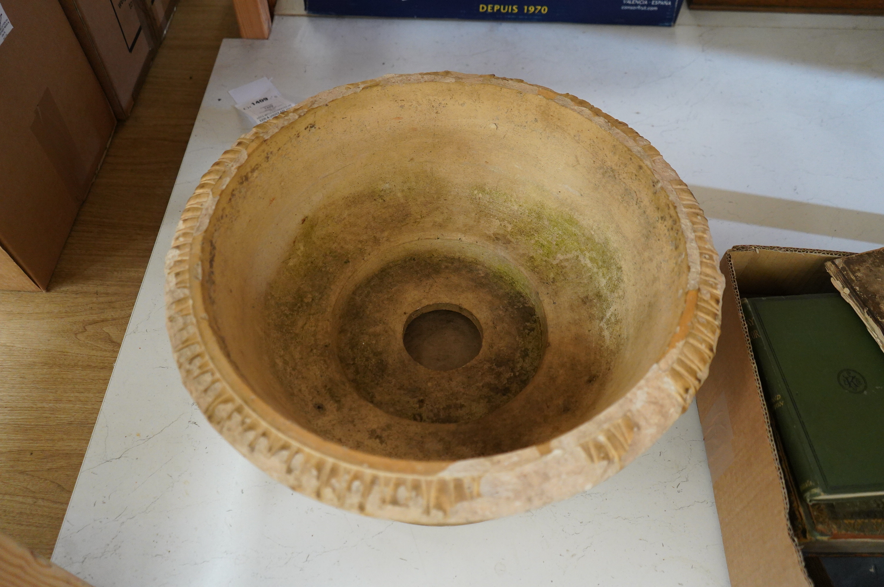 A buff coloured weathered earthenware jardiniere on stand, 48cm diameter
